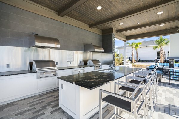 Outdoor grill area with modern patio seating at Sanctuary at Daytona Apartments