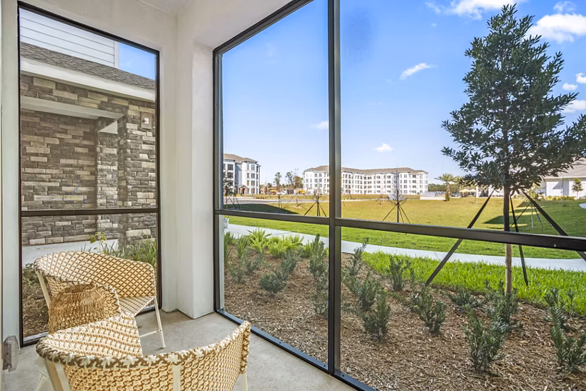 Patio with cozy seating and lush greenery at Sanctuary at Daytona Apartments, offering luxury living in a serene setting