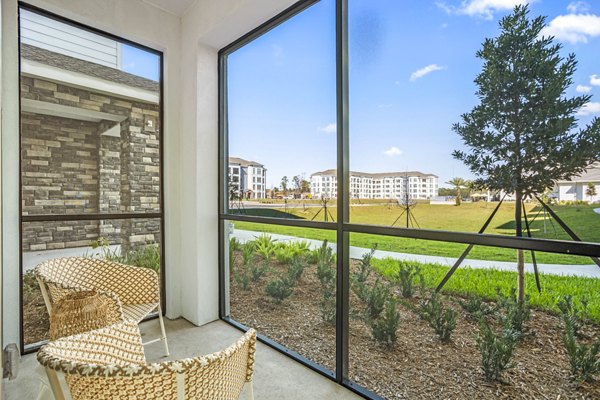 Patio with cozy seating and lush greenery at Sanctuary at Daytona Apartments, offering luxury living in a serene setting
