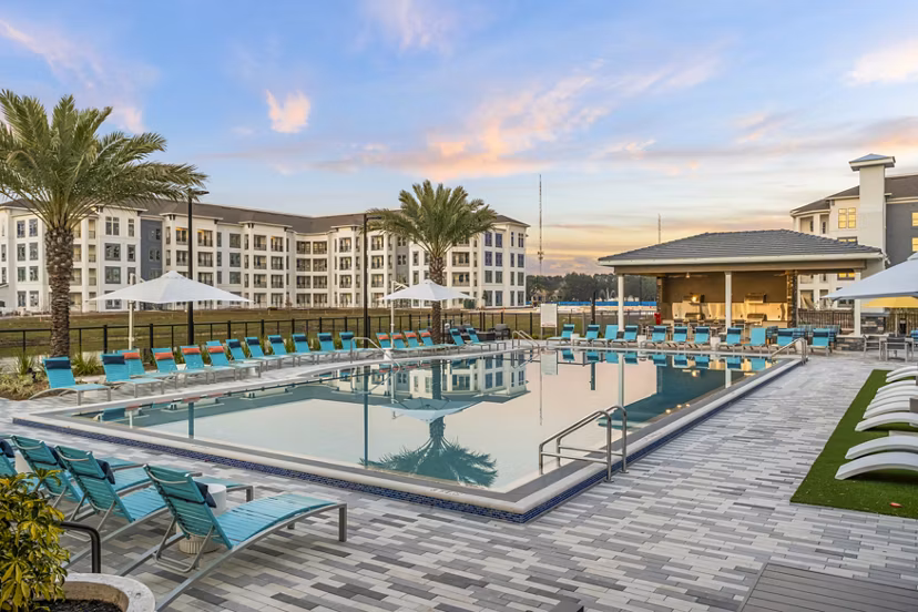 Serene outdoor pool with lounge chairs at Sanctuary at Daytona luxury apartments