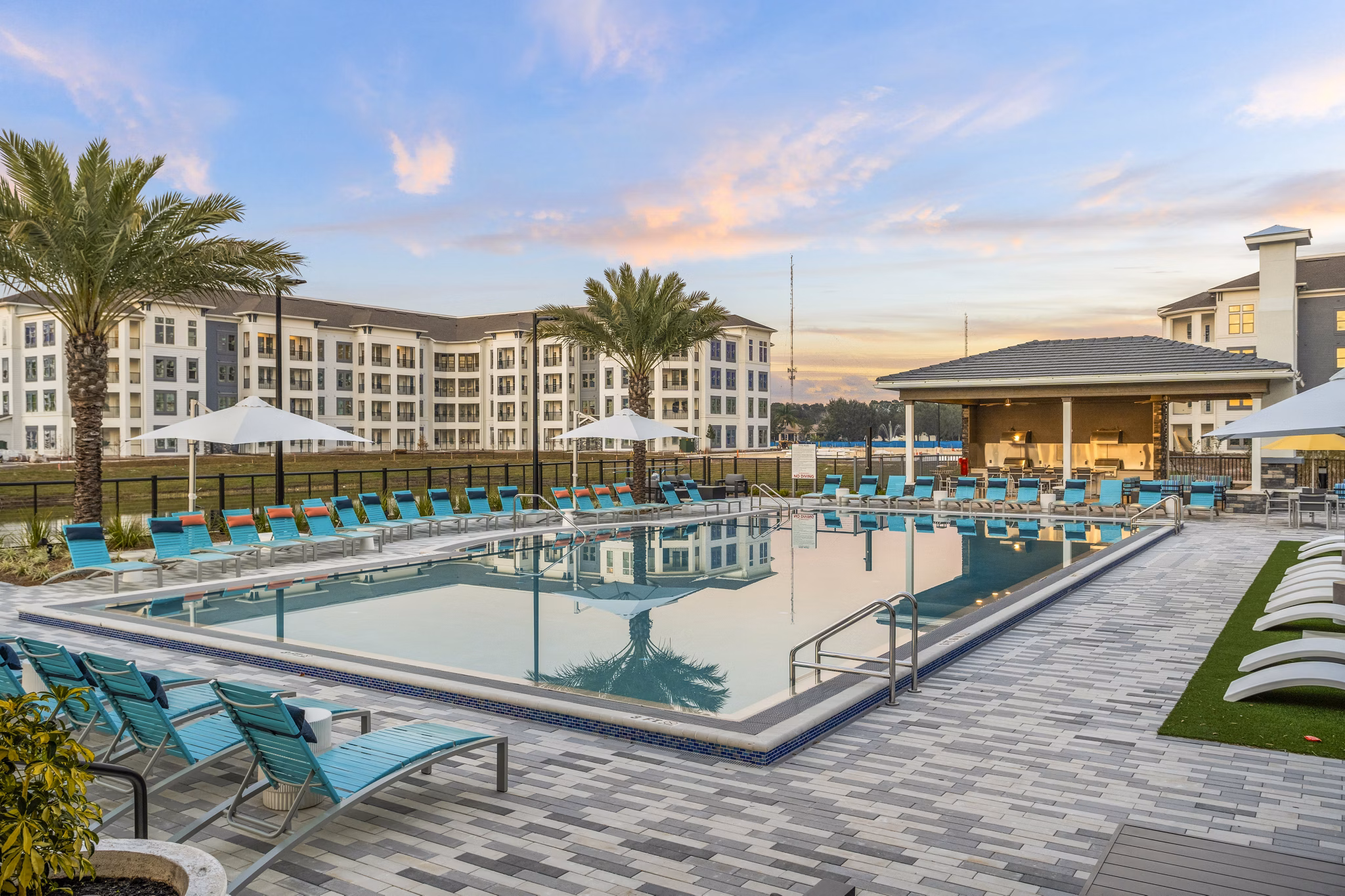 Serene outdoor pool with lounge chairs at Sanctuary at Daytona luxury apartments
