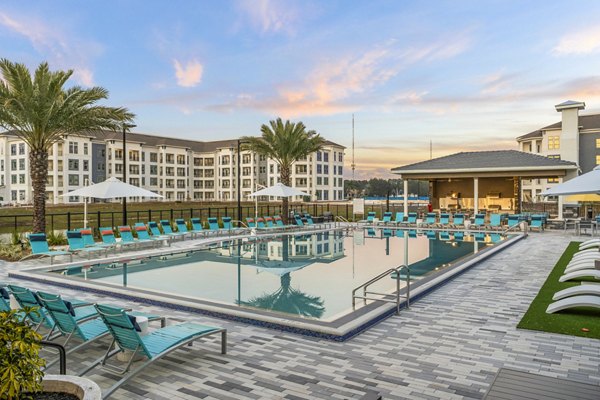 Serene outdoor pool with lounge chairs at Sanctuary at Daytona luxury apartments