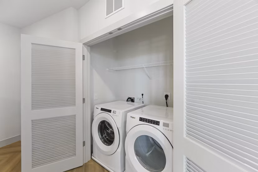 Bright laundry room with modern machines at The Ian Apartments
