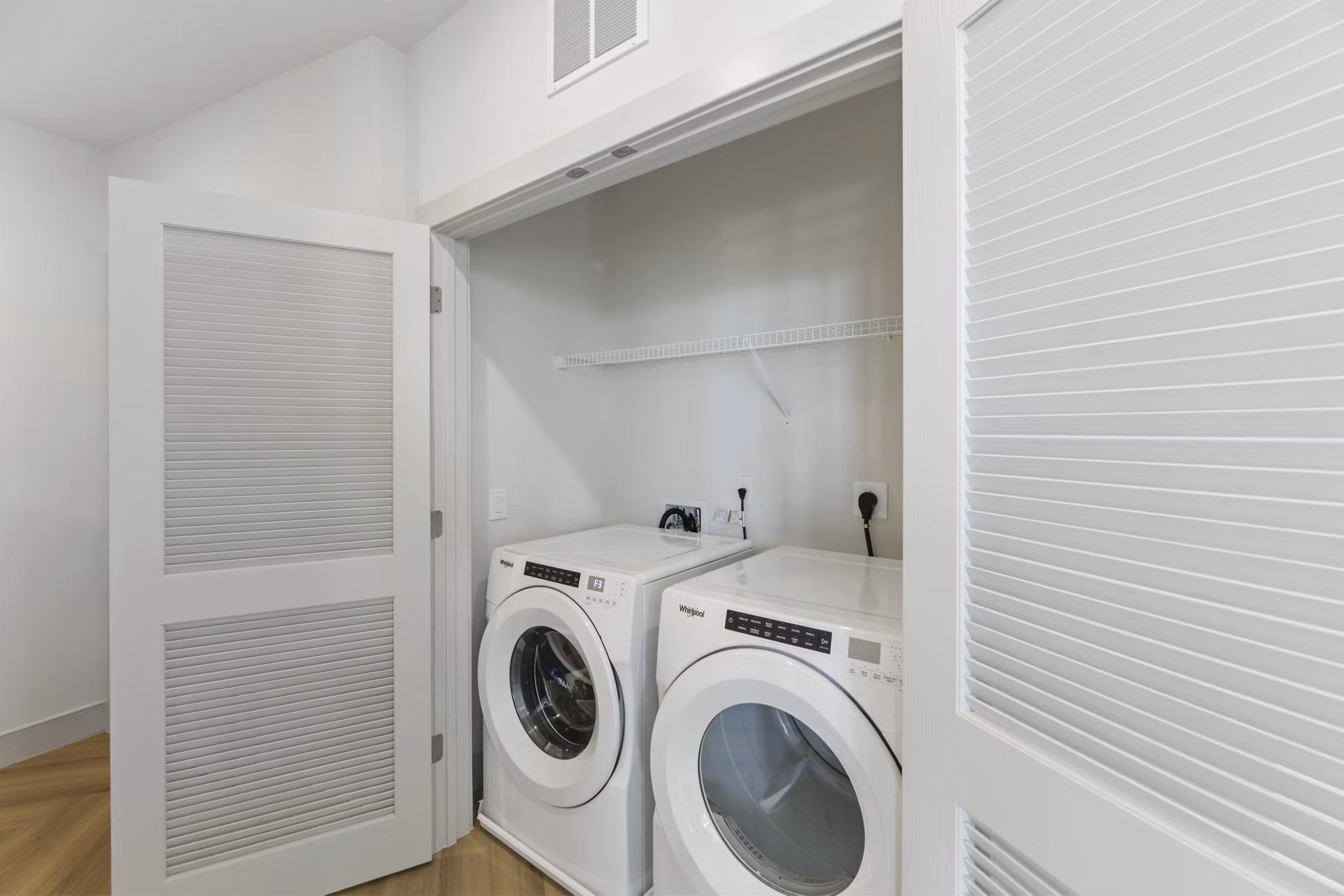 Bright laundry room with modern machines at The Ian Apartments