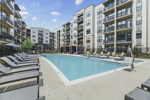 Inviting outdoor pool at The Ian Apartments offering luxury relaxation and leisure opportunities
