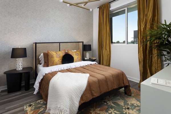 Cozy bedroom with modern furnishings at Broadstone Edition Apartments, featuring luxurious bedding and ambient lighting for a serene ambiance