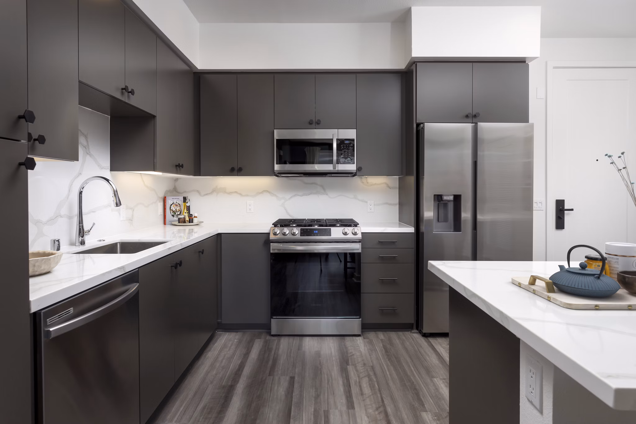 Modern kitchen with island and stainless steel appliances at Broadstone Edition Apartments