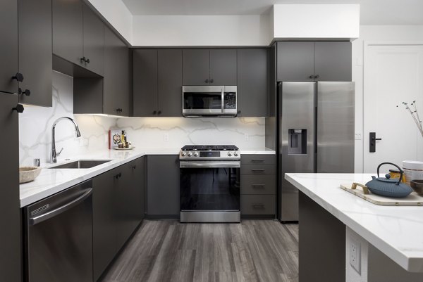 Modern kitchen with island and stainless steel appliances at Broadstone Edition Apartments