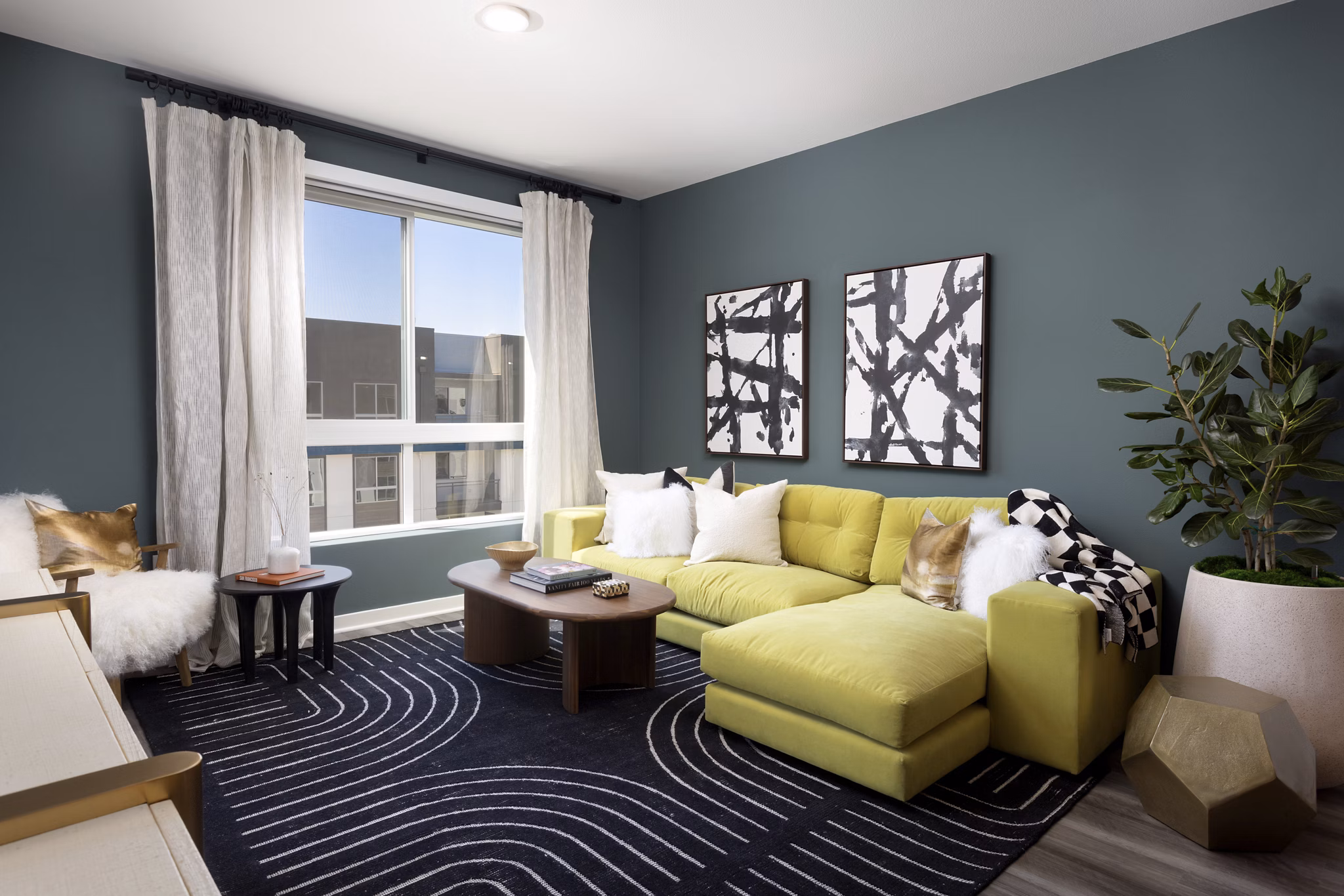 Modern living room with chic decor and large windows at Broadstone Edition Apartments