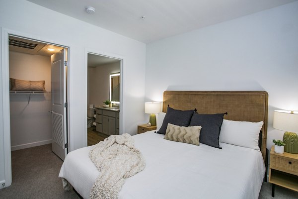 Bedroom featuring modern decor and ample natural light at theApex @ Meadows Apartments