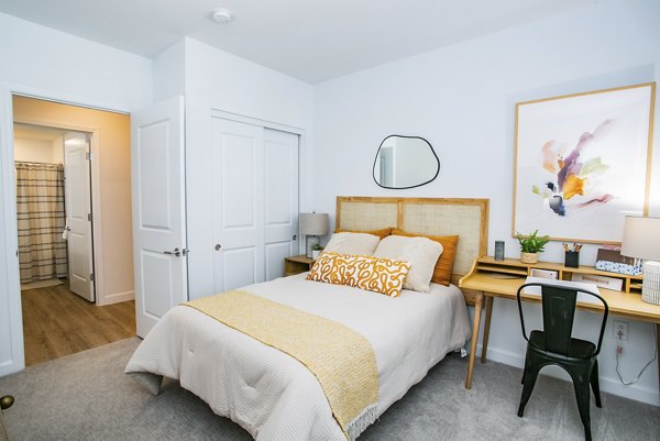 Cozy bedroom with modern decor at The Apex @ Meadows Apartments, offering luxury living in a serene setting
