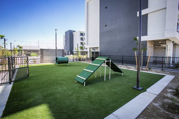 Modern dog park at TheApex @ Meadows Apartments with agility equipment and seating areas for resident pet owners