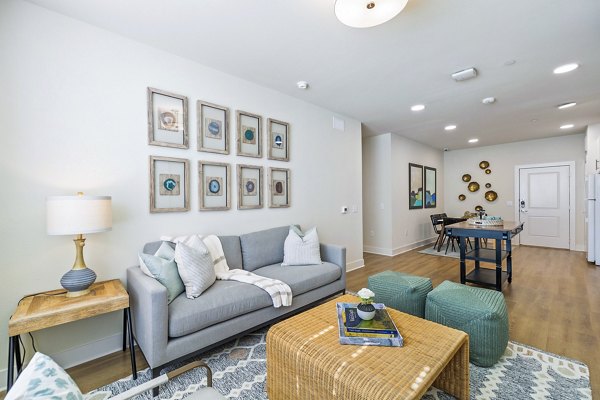 Modern living room with cozy seating and large windows in Birchway Spring Cypress Apartments