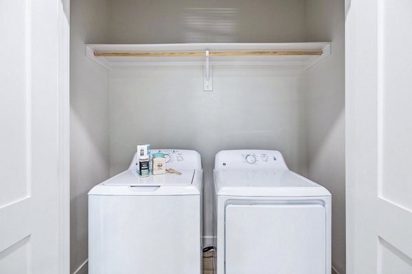 Laundry room featuring modern appliances at Birchway Spring Cypress Apartments