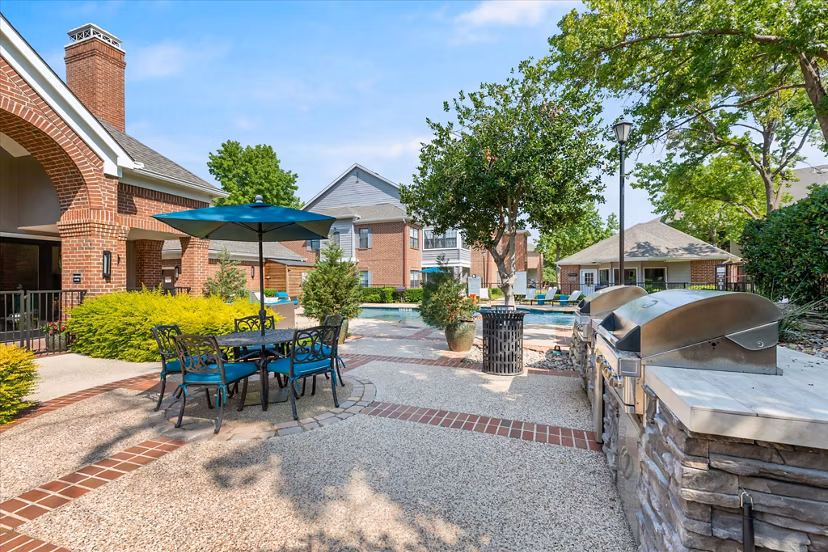 Outdoor grill area with modern seating at Madison at Melrose Apartments, ideal for social gatherings and BBQs