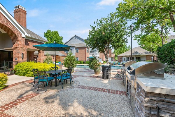 Outdoor grill area with modern seating at Madison at Melrose Apartments, ideal for social gatherings and BBQs