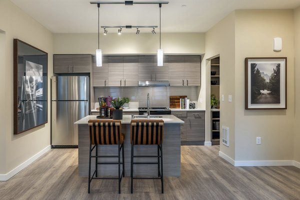 Modern kitchen with stainless steel appliances and sleek cabinetry in Traverse North Bend Apartments