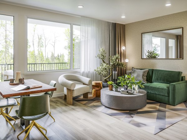 Bright living room with modern decor and large windows at Traverse Apartments, offering luxury living in a serene environment