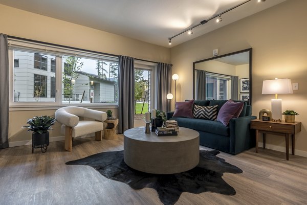 Modern living room with stylish furnishings and large windows in Traverse North Bend Apartments