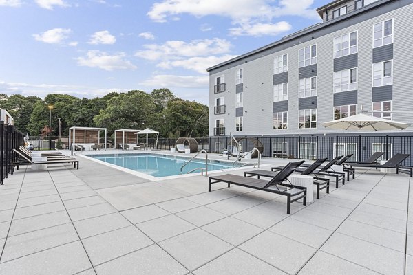 Infinity pool with sun deck at Sanctuary at Winchester North Apartments, offering luxurious relaxation in a serene setting