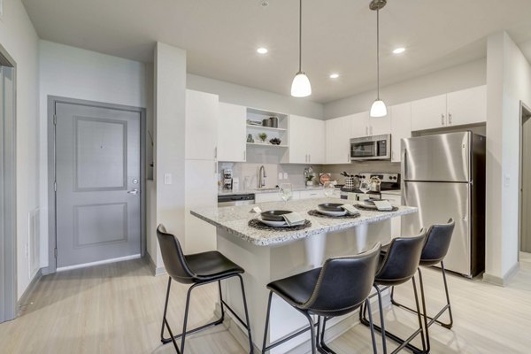 Sleek kitchen with stainless steel appliances at Inscribe Apartments