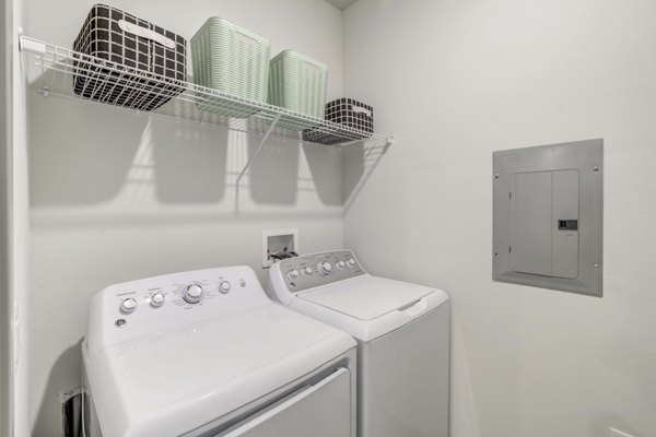 Laundry room with modern machines and folding area at Inscribe Apartments, Greystar luxury apartments in a convenient location
