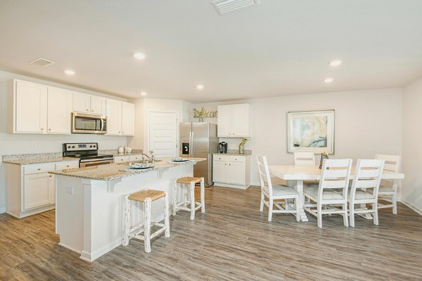 Dining area with chic decor and modern lighting at Sunset Village Apartments