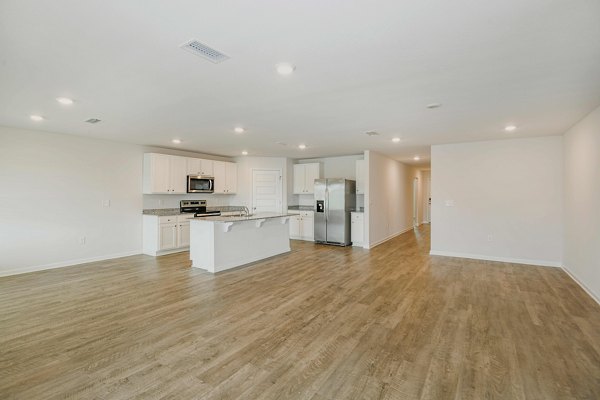 Spacious kitchen and dining area with sleek countertops in Sunset Village Apartments, offering luxury living