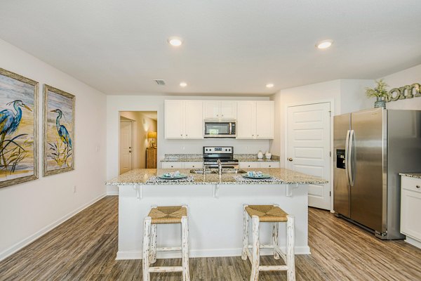 Modern kitchen with stainless steel appliances at Sunset Village Apartments