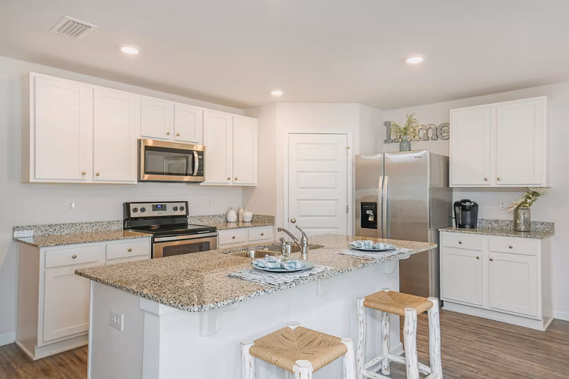 Kitchen featuring modern appliances and granite countertops at Sunset Village Apartments