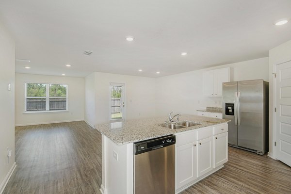 Modern kitchen with stainless steel appliances in Sunset Village Apartments