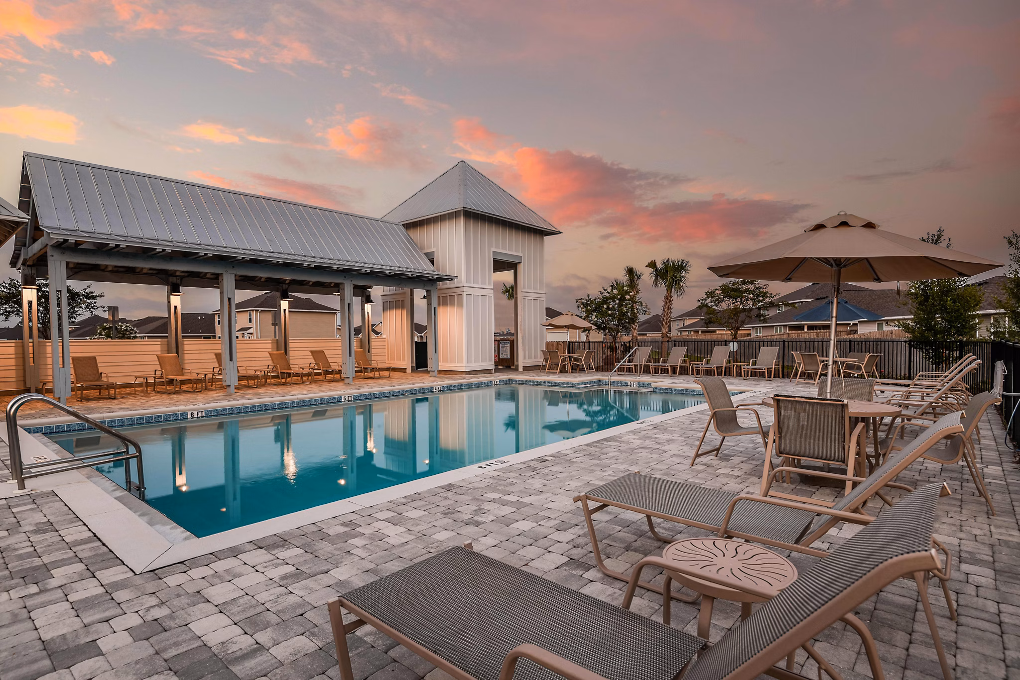 Elegant pool with lounge chairs at Sunset Village Apartments offering a relaxing outdoor experience