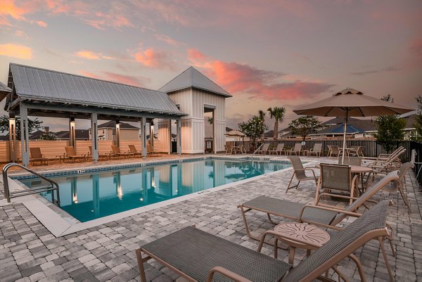 Elegant pool with lounge chairs at Sunset Village Apartments offering a relaxing outdoor experience