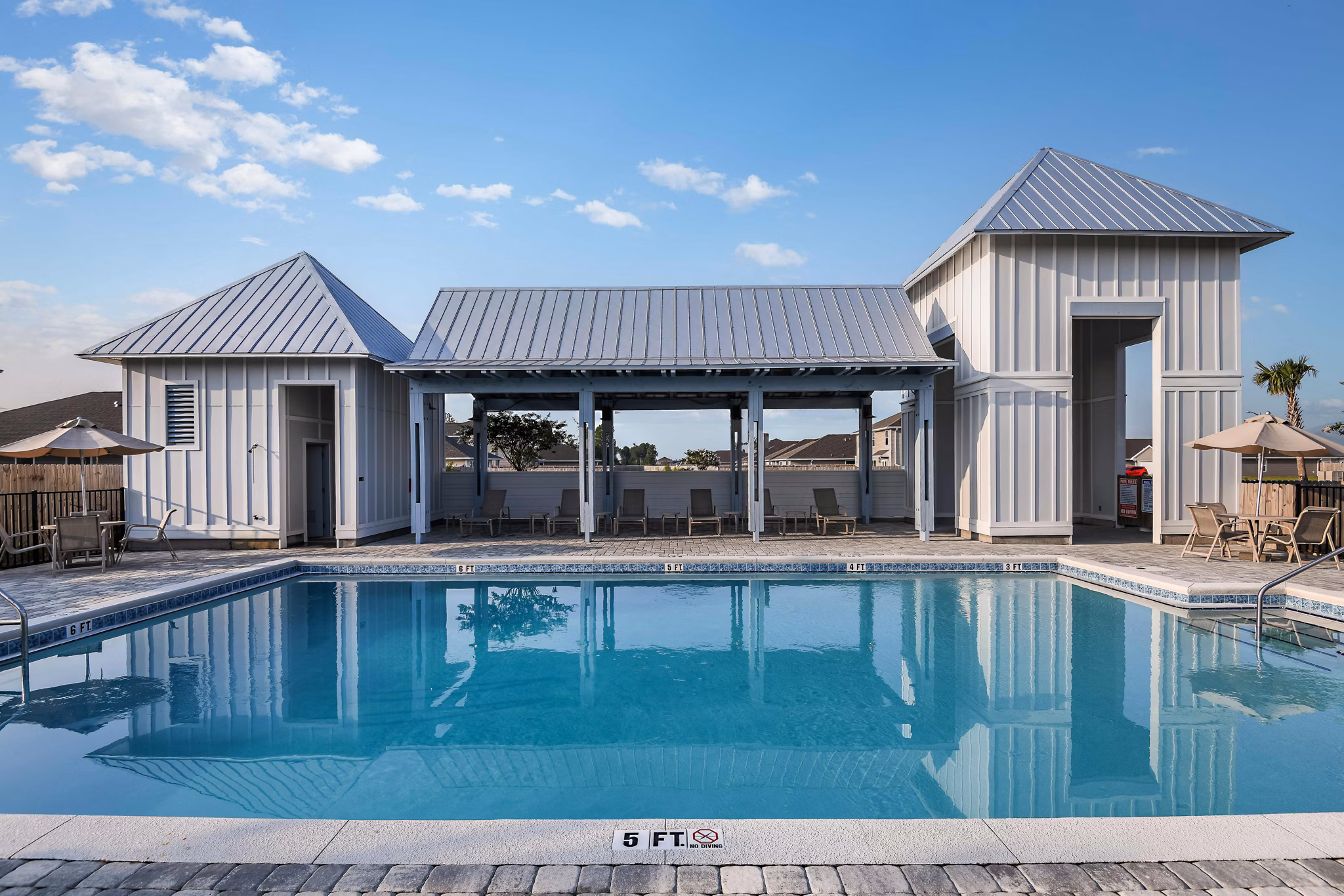 Luxurious pool with lounge chairs at Sunset Village Apartments, a Greystar community