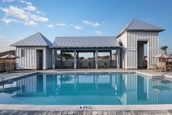 Luxurious pool with lounge chairs at Sunset Village Apartments, a Greystar community