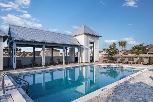 Resort-style pool with lounge chairs at Sunset Village Apartments, ideal for relaxation in luxurious surroundings