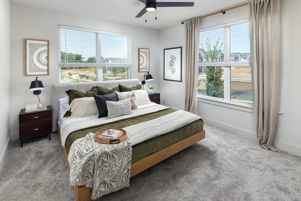 Spacious bedroom featuring elegant furnishing and large windows in Elan Brookwood Apartments