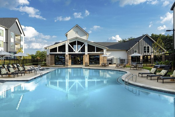 Resort-style pool with lounge chairs at Elan Brookwood Apartments, offering luxury outdoor relaxation