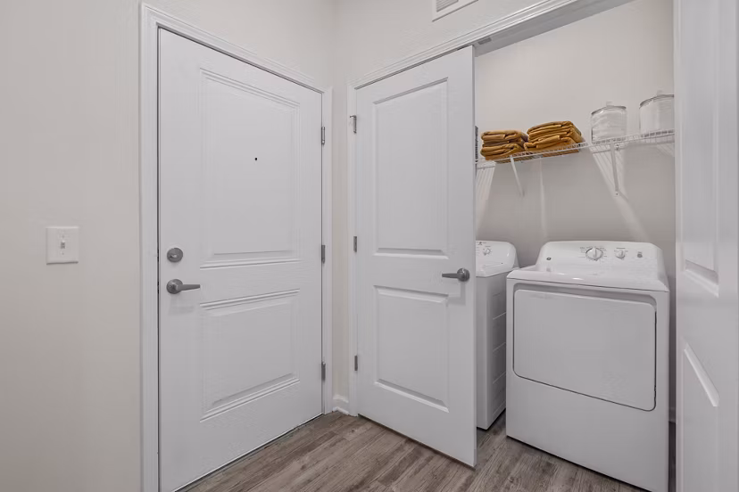 Laundry room with modern appliances at Coastal Exchange Apartments, offering convenience and efficiency for luxury living near the coast