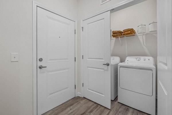 Laundry room with modern appliances at Coastal Exchange Apartments, offering convenience and efficiency for luxury living near the coast
