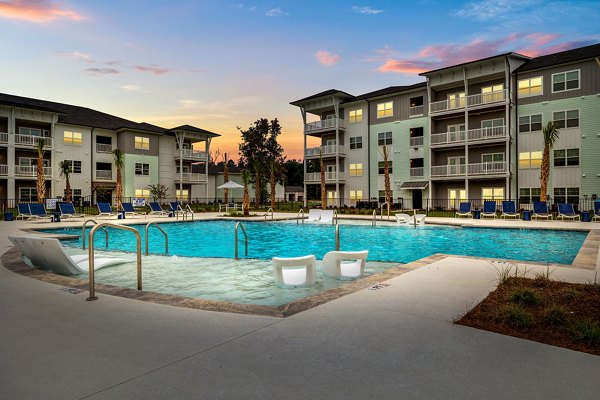 Resort-style pool with lush landscaping at Coastal Exchange Apartments offering luxury living