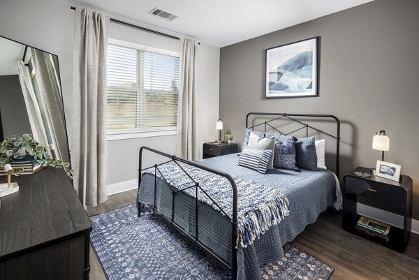 Modern bedroom featuring elegant decor and natural lighting at Prose Rhyne Apartments
