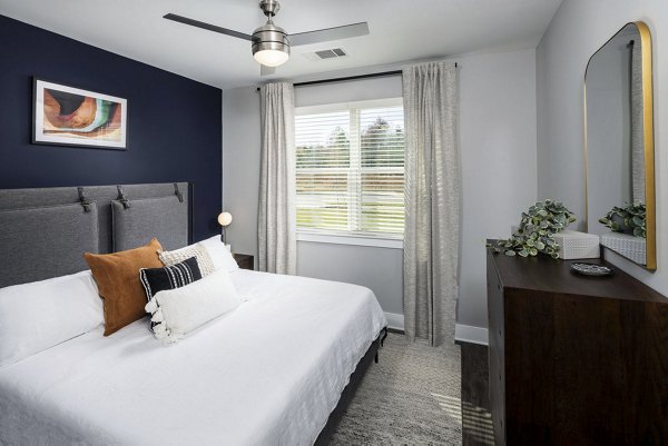 Modern bedroom with plush bedding and stylish decor at Prose Rhyne Apartments