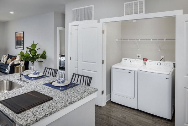Laundry room featuring modern appliances at Prose Rhyne Apartments