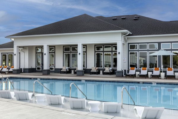 Olympic-sized outdoor pool at Prose Rhyne Apartments with lounging areas and scenic views