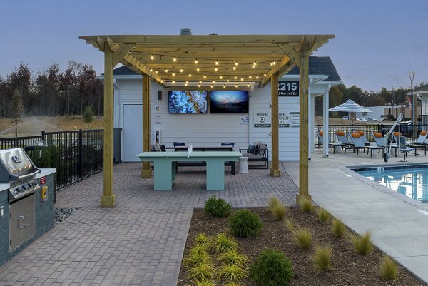 Outdoor grill area with modern seating at Prose Rhyne Apartments
