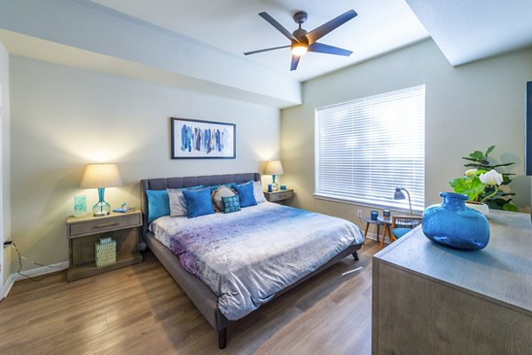 Modern bedroom with sleek decor and large window at 4001 Midtown Apartments, offering luxury living in a prime urban location
