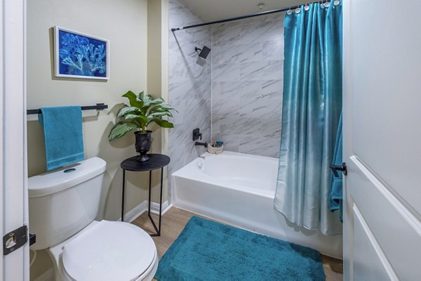 Modern bathroom with marble countertops and large mirror in 4001 Midtown Apartments