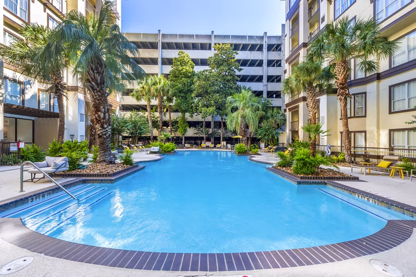 Refreshing pool at 4001 Midtown Apartments with comfortable lounge chairs and lush greenery