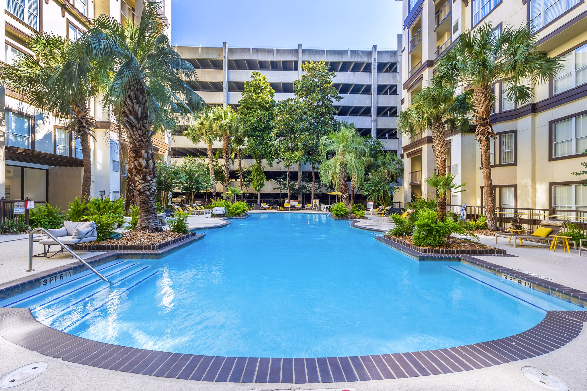 Refreshing pool at 4001 Midtown Apartments with comfortable lounge chairs and lush greenery